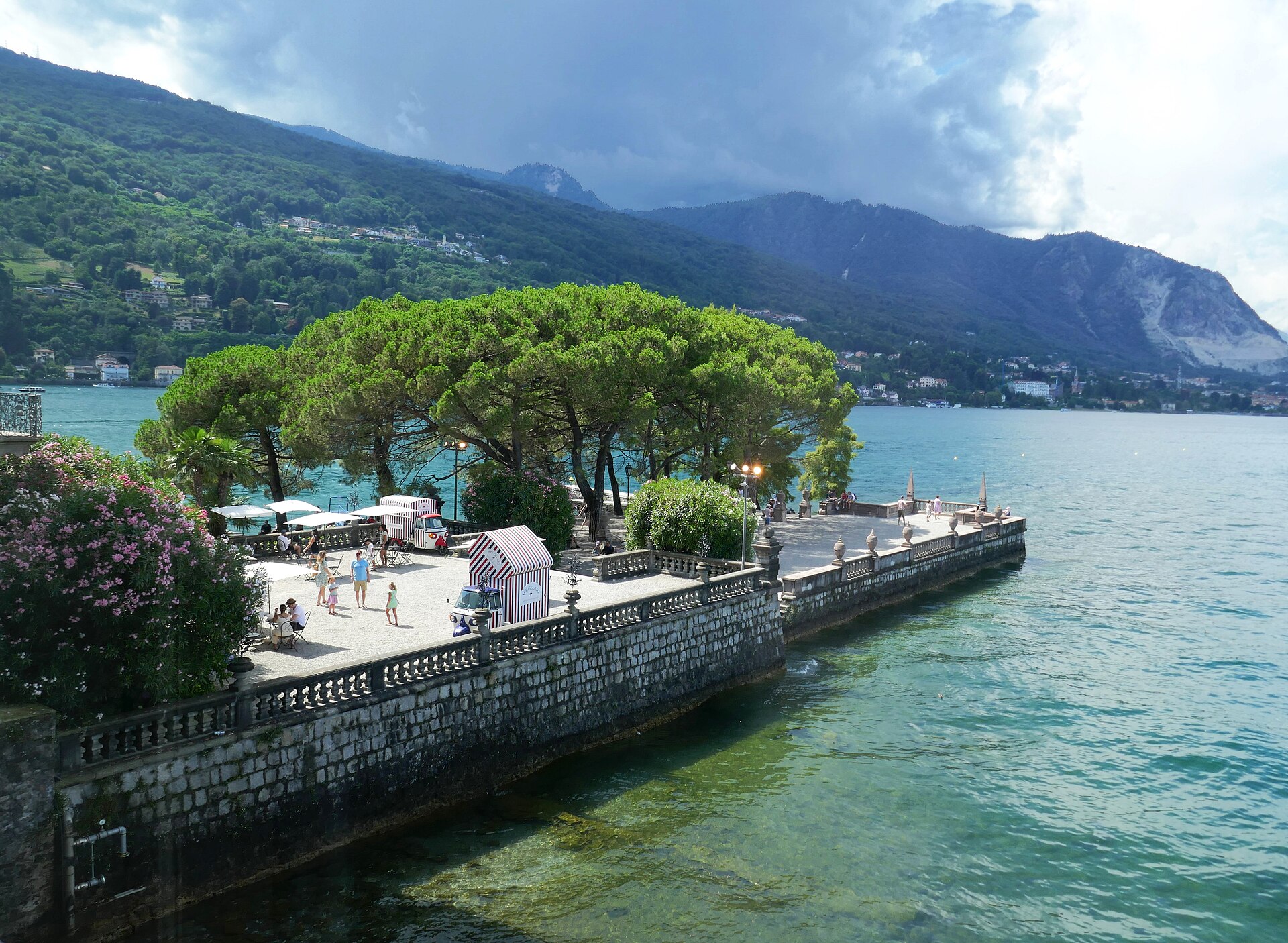 Terrazza panoramica sul lungolago di Isola Bella, con pini e palazzi storici sullo sfondo del Lago Maggiore